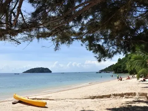 A quiet beach on Manukan Island with an island on the horizon